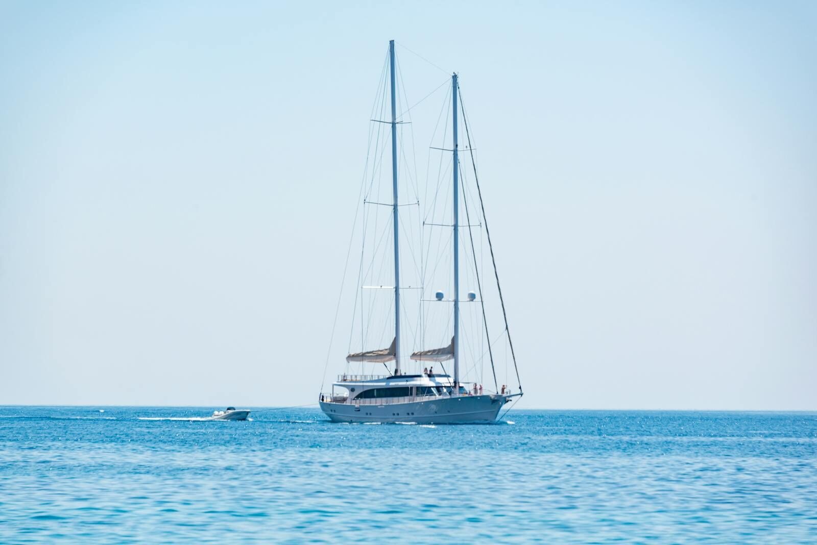 Elegant sailing yacht cruising on the calm blue waters under a clear sky.